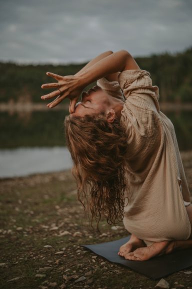 Laura Pilsel übt eine sanfte Asana im Morgenlicht, verbunden mit der natürlichen Energie der Umgebung.